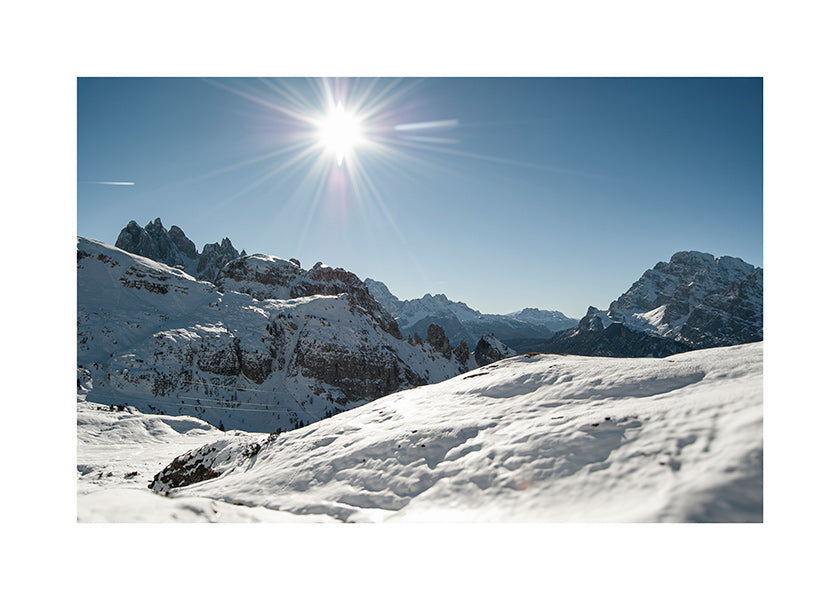 Art de paysage: chaîne de montagnes enneigée et soleil