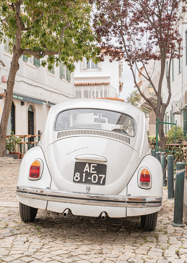 Cuadro de ciudades con coche clásico en empedrado