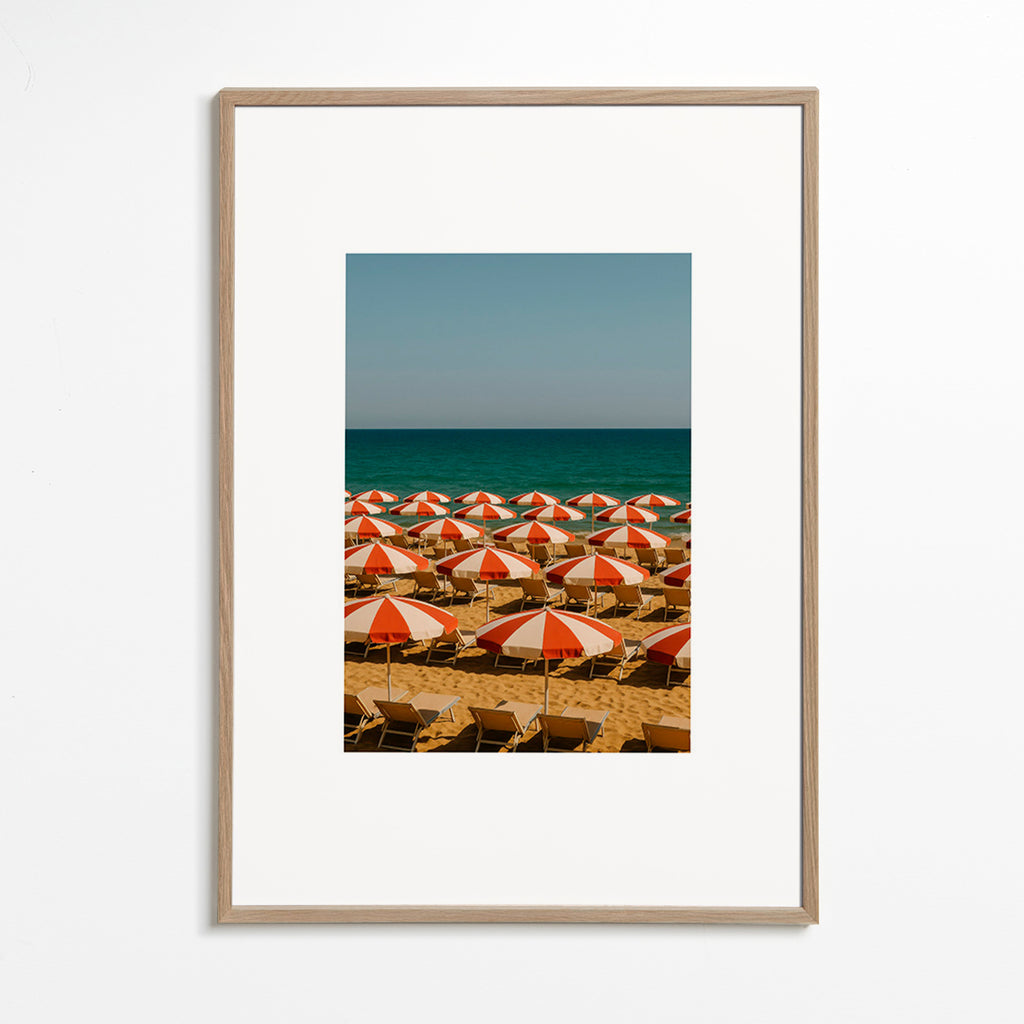 Cuadro de paisaje con sombrillas rojas en playa – Oak Frame