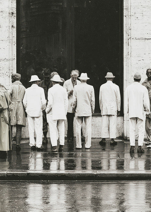 Photographie noir et blanc d'hommes de dos sous la pluie